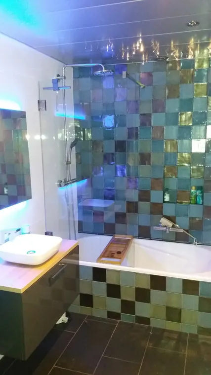 Dezelfde badkamer met turquoise en paarse RGB-sfeerverlichting