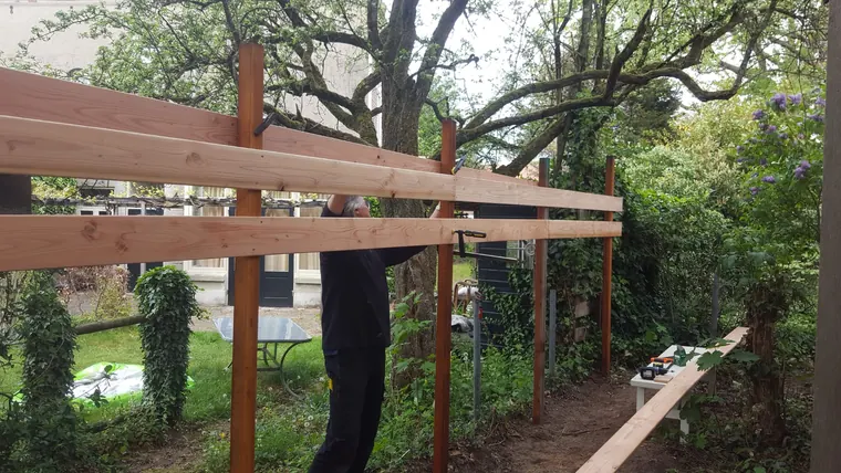 Houten buitenconstructie tijdens de opbouw in een groene tuin